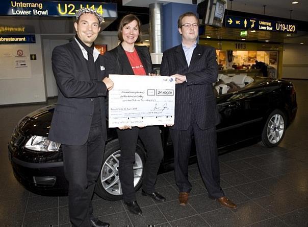 Roger Cicero (links) und Saab-Pressesprecher Patrick Munsch übergaben Kathrin Wieland, Geschäftsführerin der Kinderhilfsorganisation Save the Children, den symbolischen Scheck über 21161 Euro. Foto: Auto-Reporter/Saab